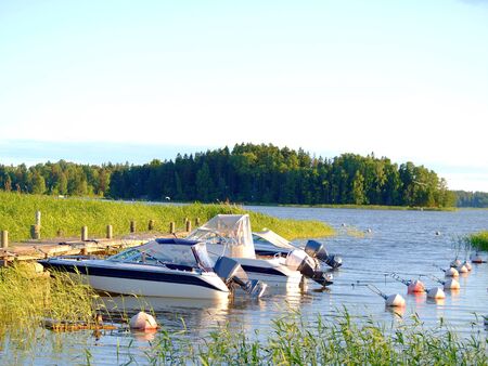 Boats at bay, at the pier, at summer, blue sky and waterの写真素材