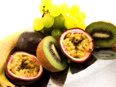 Assorted fruits, isolated on a silver plate, towards white backgroundの写真素材