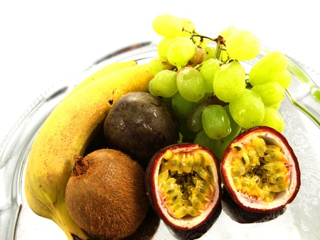 Assorted fruits, isolated on a silver plate, towards white backgroundの写真素材