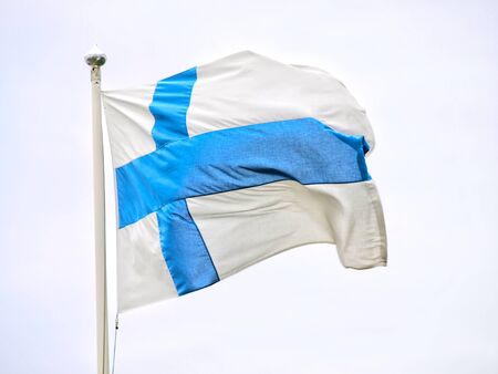 Flag of Finland waving in the wind, on a poleの写真素材