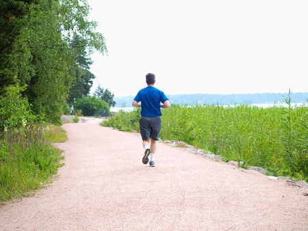 Person running alone on gravel road, at summerの写真素材