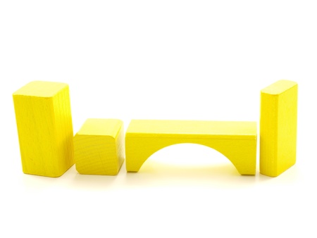 Wooden brick pieces of yellow color, isolated towards whiteの写真素材