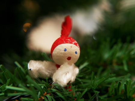 Little santa claus, sitting in a plastic christmas treeの写真素材