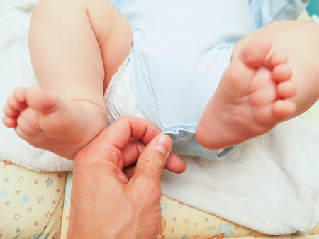 Dressing up a baby boy after bath and diaper changeの写真素材