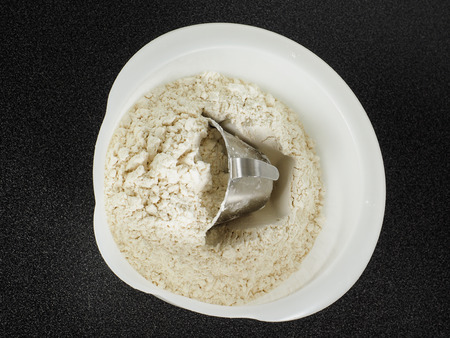 Measurement tool in a bowl of wheat flourの写真素材