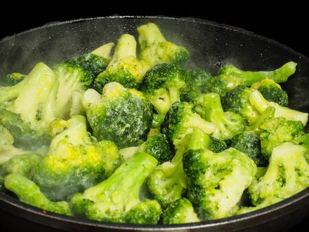 Thawing frozen green broccoli in a hot fry panの写真素材