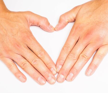 Adult person creating heart with hands towards grey whiteの写真素材