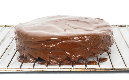 Chocolate icing dripping off from freshly made sacher torte cakeの写真素材
