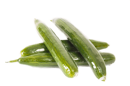 Cucumbers in heat shrink film, in a pile, isolated towards white backgroundの写真素材