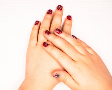 Little girl with beautiful manicure in dark pink, towards white paperの写真素材