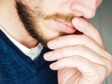 Male person, at closeup with fingers in beardの写真素材