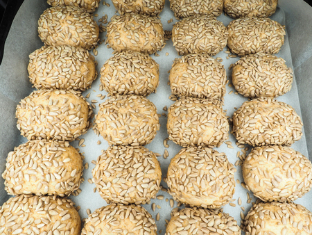 Closeup of freshly made sunflower seed buns on a waxed paper tray at close-upの写真素材