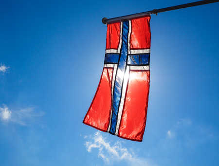 Norwegian flag up close, towards the sun on beautiful blue skyの写真素材