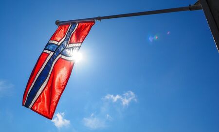 Norwegian flag up close, towards the sun on beautiful blue skyの写真素材