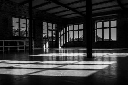 Windows casting shadows on the floor in an empty venueの写真素材
