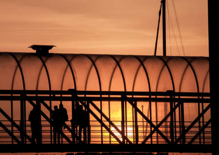 People standing in a walkway by sunsetの写真素材