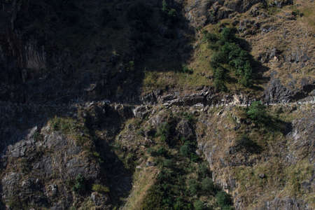 Two cars driving close to a steep edge on the road to Manang, Annapurna circuit, Nepal