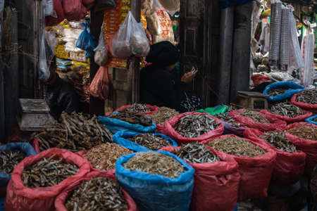 December 22 - Kathmandu, Nepal: Two unidentified vendors sells dried fish and other consumables at a local street market on December 22, 2019 in Kathmandu, Nepalのeditorial素材