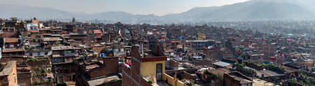 Bhaktapur, Kathmandu, Nepal - December 23, 2019: Panoramic cityscape view from a roof top over brick houses and temples with unidentified people, their gardens, plants and laundry on the roofs on December 23, 2019 in Bhaktapur, Kathmandu, Nepalのeditorial素材