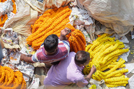 Kolkata, India - February 2, 2020: Two unidentified men from above sells orange and yellow marigold...