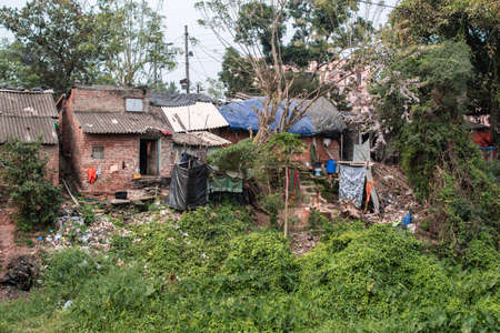 Easy residential homes with plastic waste and laundry drying in the slums of Bhubaneswar, India