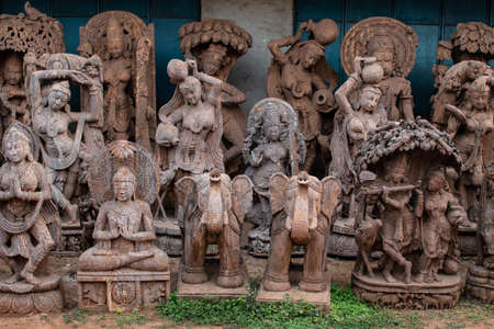 Several brown religious stone sculptures on display for sale