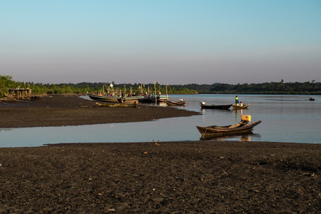 Chaung Thar, Myanmar - December 26, 2019: People in traditional wooden fishing boats by the coast...