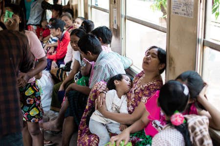 Yangon, Myanmar - December 31, 2019: Busy everyday life travelling on the circle train while buying...