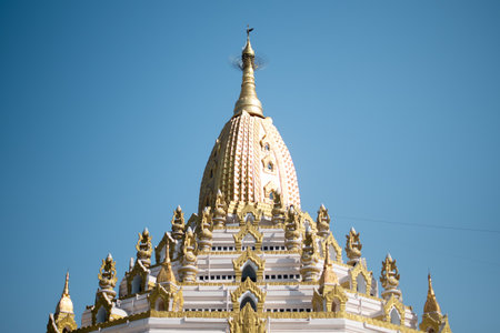 YANGON, MYANMAR - JANUARY 1 2020: The top part of Swe Taw Myat Pagoda with golden details and decorations against a blue skyのeditorial素材