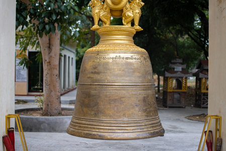 BAGAN, NYAUNG-U, MYANMAR - 2 JANUARY 2020: A large massive buddhist bell hangs still and silently by a historic pagoda templeのeditorial素材