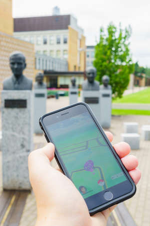 Estonia, Tallinn- JULY 23, 2016 : Walk with Pokemon Go game.  Apple iPhone 6 in one hand showing its...