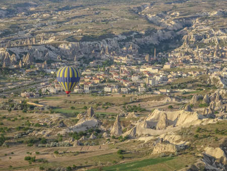 Hot air balloon flying over landscape at Cappadocia Turkeyのeditorial素材