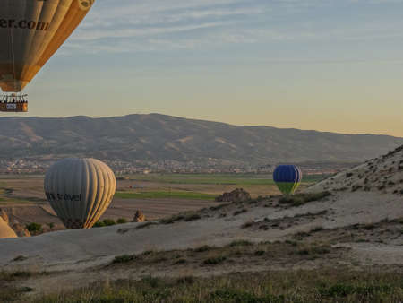 Hot air balloon flying over landscape at Cappadocia Turkeyのeditorial素材
