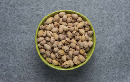 Pistachio nuts in a green plateの写真素材