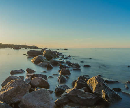 Beautiful Baltic sea landscape with stone breakwater. Tranquil long exposure landscapeの写真素材