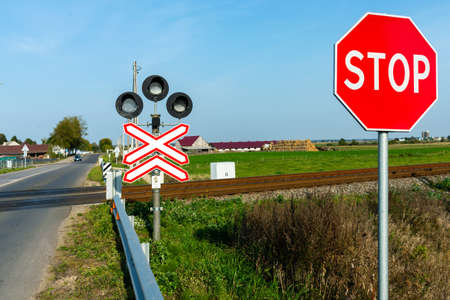 Railroad crossing and stop sign in farmland ralway level crossing with warning sign stop nobody...