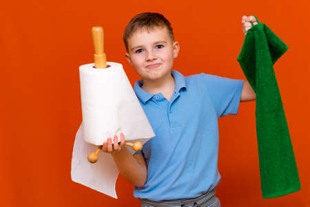 Portrait of a Caucasian boy. The boy holds a paper towel, the other hand used to towel. Which is better. Housewives concept.の写真素材