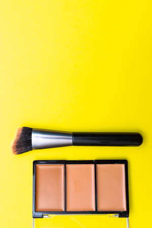Flat lay top view make up shadow brush decorative cosmetics on yellow background. Make up concept. Copy space image for your text.の写真素材