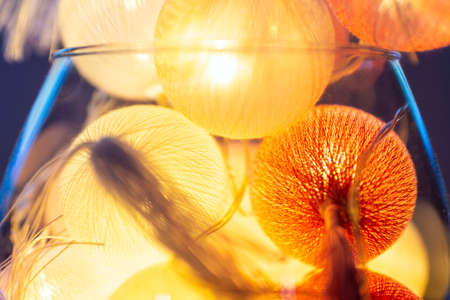 Close up A glass cup with large shining gold red balls on a table inside for winterの写真素材