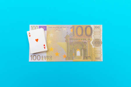 100 Euro With One Note and small toy playing cards lie on banknote blue backgroundの写真素材