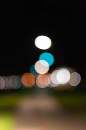 Blurred image.Small town Night city street colorful lights bokeh backgroundの写真素材