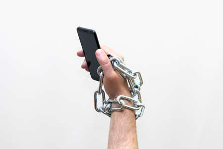 Close up Man holding smartphone with metal chain on white background. concept security,Studio shoot.