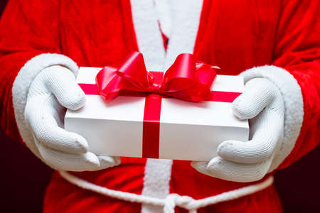 Cropped view of santa claus holding gift box.Close up front view selective focus.Christmas concept.の写真素材