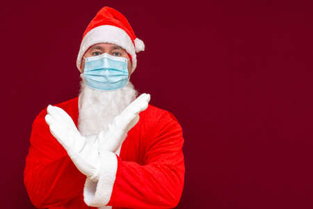 Closeup santa claus costume rejection expression crossing arms and palms doing negative sign,wears medical mask.Front view image.の写真素材