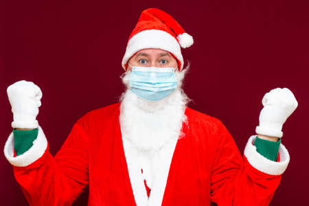 angry santa claus clenched fists wears face medical mask, tired of new year and christmas.Close up front view image.の写真素材