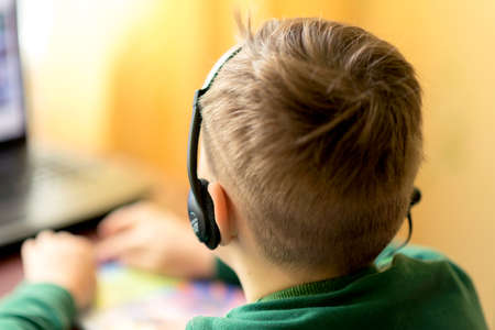 Close up A blurry selektive focus image.The boy learns at home with laptop at a distance remote...