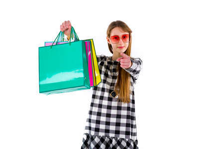 Happy teenage girl holding colored shopping bags over white studio background.Mock up copy space banner.shopping concept.の写真素材