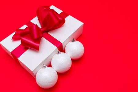 christmas gift and white balls on red bright backgroundの写真素材