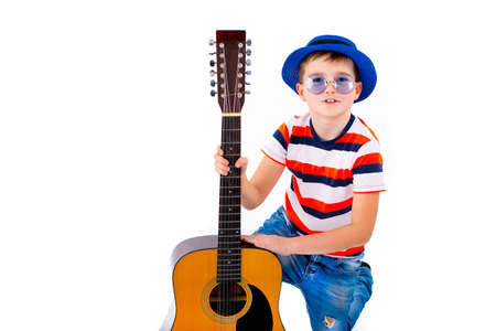 A boy kid holding guitar on a white background in the studio.の写真素材