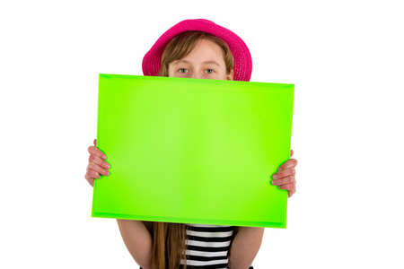 Happy girl child holding and hiding under empty blank paper isolated on white background.copy space banner advertisementの写真素材